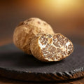Tuber borchii di Categoria EXTRA freschi, con un esemplare tagliato che mostra l’interno marrone naturalmente venato